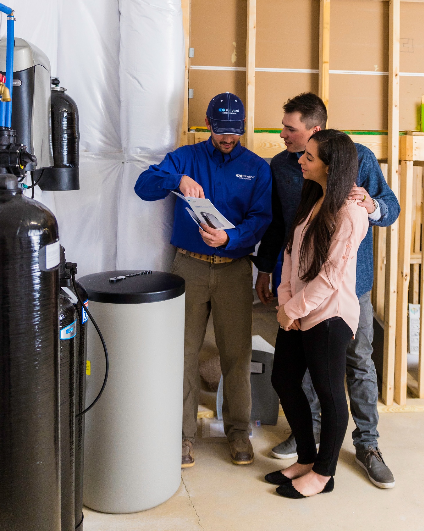 Kinetico technician showing water system options to a young couple