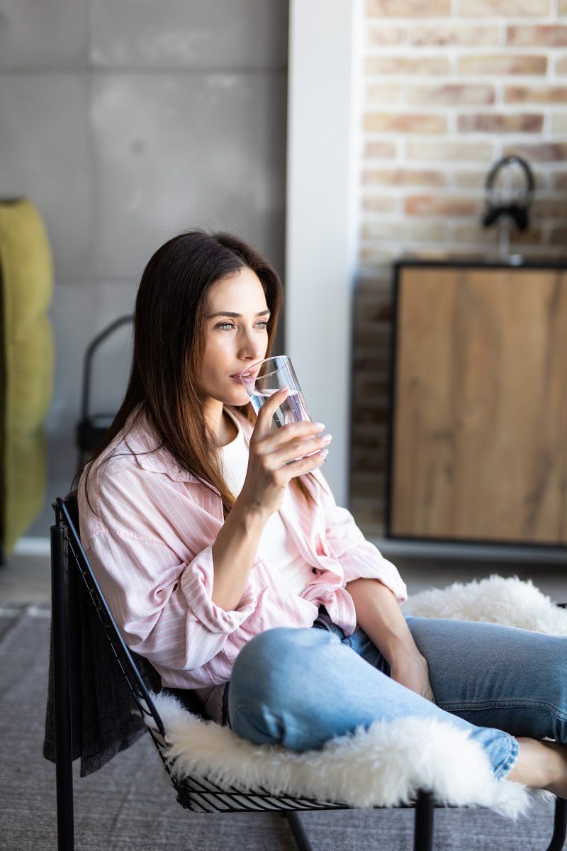 Woman in pink drinking a glass of water